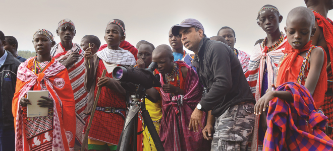 Biologist Munir Virani helps students in our Masai Mentors program find vultures using a scope.