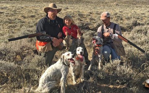 Hunters in the field with dogs