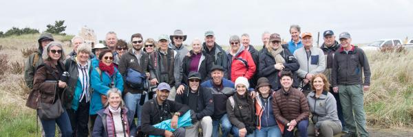 A large group photo of The Peregrine Fund's Board of Directors bird watching at Long Beach, Washington